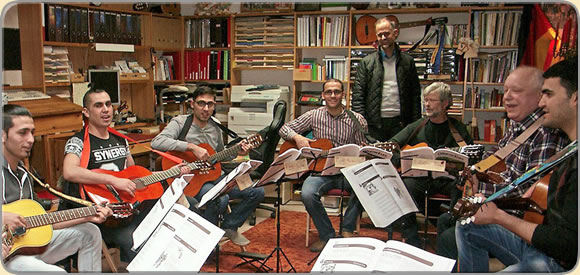 Sechs junge Flüchtlinge lernen bei Rainer Schmidt das Gitarrespiel